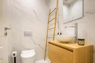 a bathroom with a sink and a toilet at Art Deco 21 Luxury 2BR Apartment Downtown Metro AC in Porto