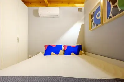 a bedroom with a bed with two blue pillows at Bonfim Garden Apartment Near Metro & City Center in Porto