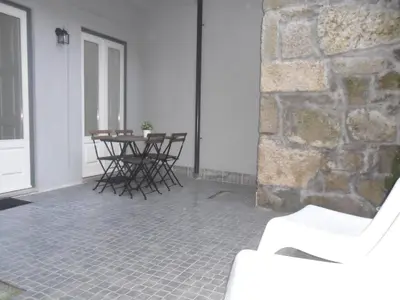 a room with a table and chairs and a stone wall at Your Place Porto II in Porto