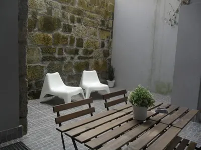 two white chairs and a wooden bench and a table at Your Place Porto II in Porto