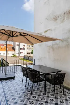 a table and chairs with an umbrella on a patio at New!! Oporto D Joao IV in Porto
