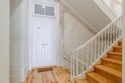 a hallway with a white door and stairs at New!! Oporto D Joao IV in Porto