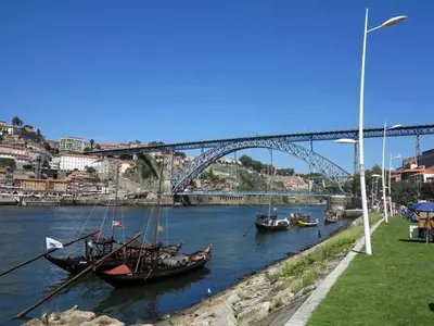 a group of boats in the water under a bridge at Miragaia Charm Apartment in Porto