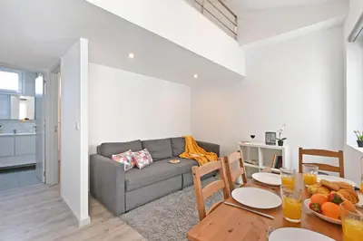 a living room with a gray couch and a table at Crystal Palace House - T2 - D13 in Porto