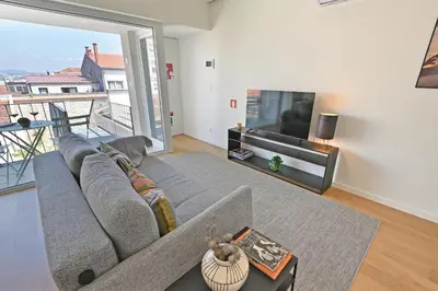 a living room with a couch and a large screen tv at Vera Cruz Porto Apartment in Porto