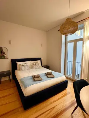 a bedroom with a large bed with a large window at Porto Suites in Porto