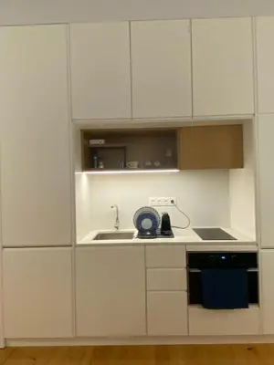 a kitchen with white cabinets and a sink at Porto Suites in Porto