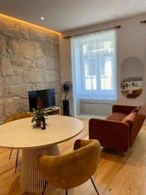 a living room with a table and chairs and a couch at Porto Suites in Porto
