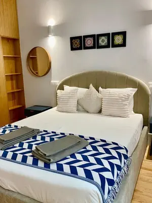 a bed with blue and white sheets and pillows at Porto Suites in Porto