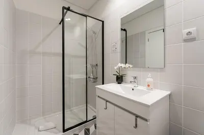 a white bathroom with a sink and a shower at GuestReady - RNB Apartments in Porto