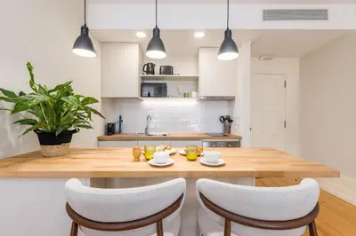 a kitchen with a wooden table and chairs at Albertina Carlos Alberto by Aspasios in Porto