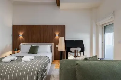 a hotel room with a bed and a piano at Albertina Carlos Alberto by Aspasios in Porto
