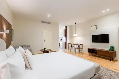 a hotel room with a bed and a television at Albertina Carlos Alberto by Aspasios in Porto