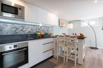 a kitchen with white cabinets and a counter top at Quinta do Vintém near WOW by HostWise in Vila Nova de Gaia