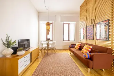 a living room with a couch and a tv at Porto Ribeira Flat in Porto