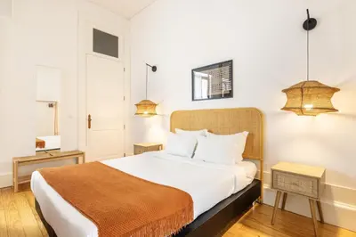 a bedroom with a large bed with white sheets at Porto Ribeira Flat in Porto