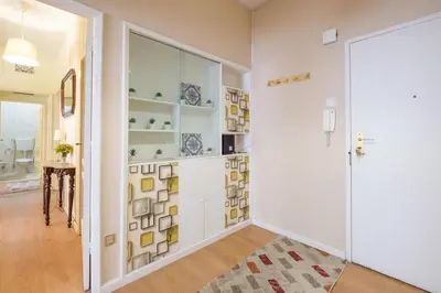a hallway with white walls and a glass door at Spacious 3 BRs Apartment, steps to Joao's station in Vila Nova de Gaia