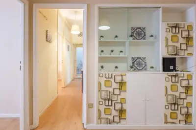 a room with a wall of shelves with books at Spacious 3 BRs Apartment, steps to Joao's station in Vila Nova de Gaia