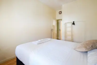 a white bed in a white bedroom with a door at Spacious 3 BRs Apartment, steps to Joao's station in Vila Nova de Gaia