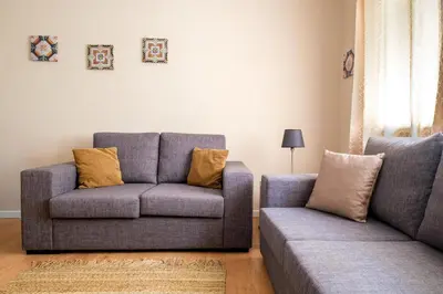a living room with a couch and a chair at Spacious 3 BRs Apartment, steps to Joao's station in Vila Nova de Gaia