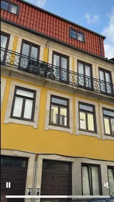 a yellow building with windows and a balcony at The Arcada House by MyMoradia in Porto