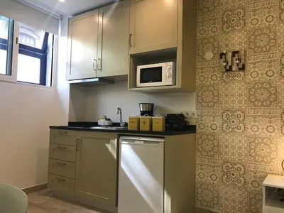 a kitchen with white cabinets and a microwave at Porto Náutico & Spa in Porto