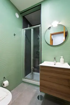 a green bathroom with a sink and a shower at Aposentus - Antas Heaven in Porto