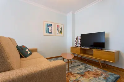 a living room with a couch and a flat screen tv at Aposentus - Antas Heaven in Porto