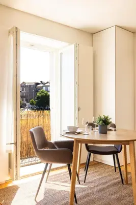 a dining room with a table and chairs and a window at Central charming flat SÉ by casaporto207 in Porto