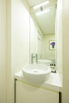 a white bathroom with a sink and a mirror at Central charming flat SÉ by casaporto207 in Porto