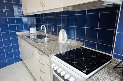 a blue tiled kitchen with a stove and a sink at Aposentus - Cest La Vie in Porto