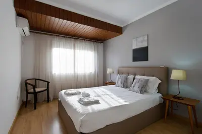 a bedroom with a large white bed with a window at APOSENTUS - The Palazzo in Porto