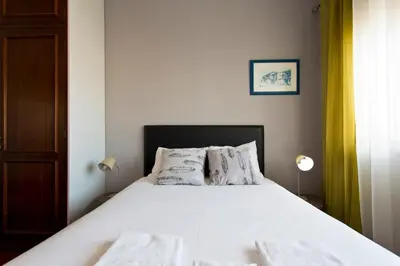 a bedroom with a bed with white sheets and pillows at APOSENTUS - The Palazzo in Porto