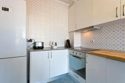 a kitchen with white cabinets and white appliances at APOSENTUS - The Palazzo in Porto