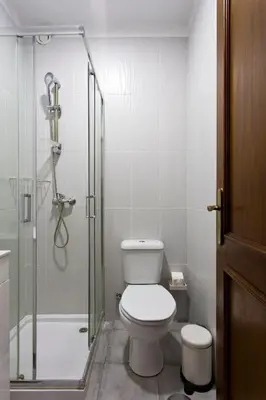 a bathroom with a toilet and a glass shower at APOSENTUS - The Palazzo in Porto
