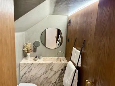 a bathroom with a sink and a wooden wall at Cais das Flores in Vila Nova de Gaia