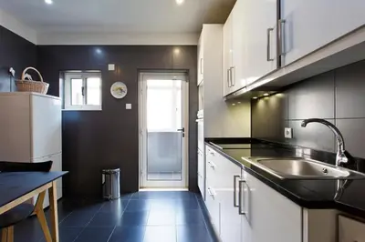 a kitchen with black and white cabinets and a sink at APOSENTUS - Serenity 2E in Porto