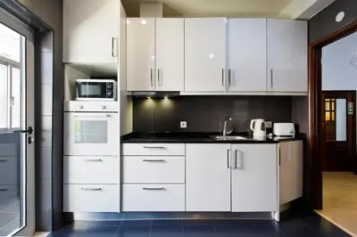 a kitchen with white cabinets and a microwave at APOSENTUS - Serenity 2E in Porto