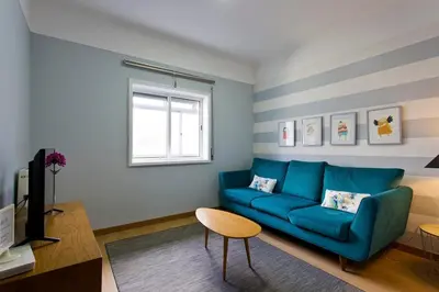 a living room with a blue couch and a window at APOSENTUS - Serenity 2E in Porto