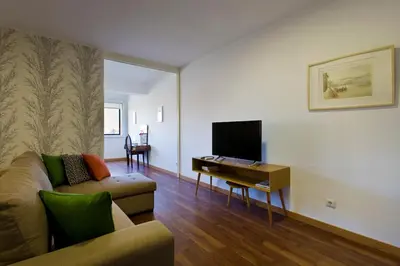 a living room with a couch and a tv at APOSENTUS - The First in Porto