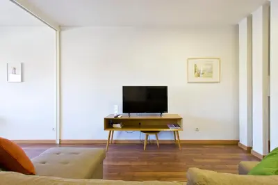 a living room with a tv on a table at APOSENTUS - The First in Porto