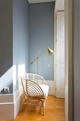 a wicker chair in a hallway with a blue wall at Aposentus - Formosa Boutique in Porto