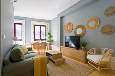 a living room with a couch and a tv at Aposentus - Formosa Boutique in Porto