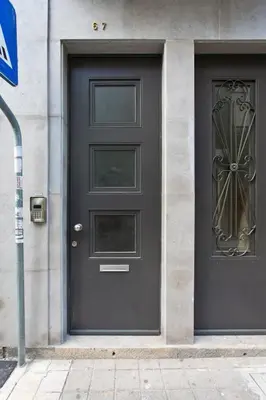a black door on the side of a building at APOSENTUS - Porto's Charming Apartment in Porto
