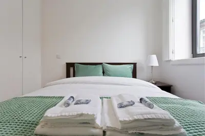 a bedroom with a bed with towels on it at APOSENTUS - Porto's Charming Apartment in Porto