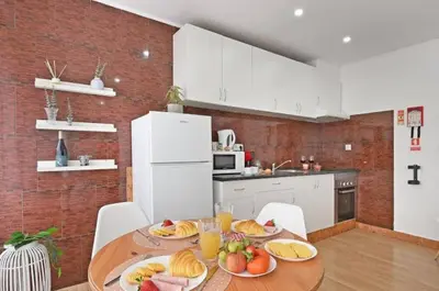 a kitchen with a table with plates of fruit on it at Apartamento Ponte D Luís in Vila Nova de Gaia