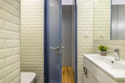 a bathroom with a blue shower door next to a sink at 741 Studio By D&S in Porto