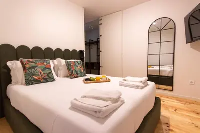 a bedroom with a large bed with towels on it at ORM - Cedofeita II Apartment in Porto