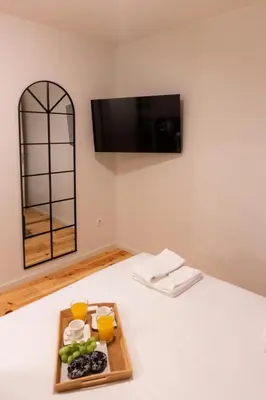 a tray of food on a bed with a plate of food at ORM - Cedofeita II Apartment in Porto