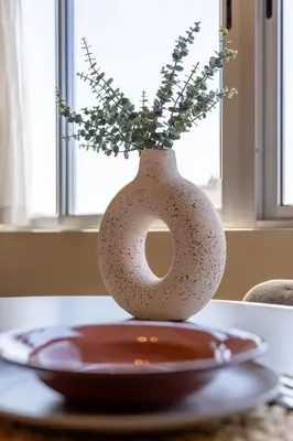a vase with flowers in it sitting on a table at Skyline Porto Apartment - Porto Velho Apt in Porto